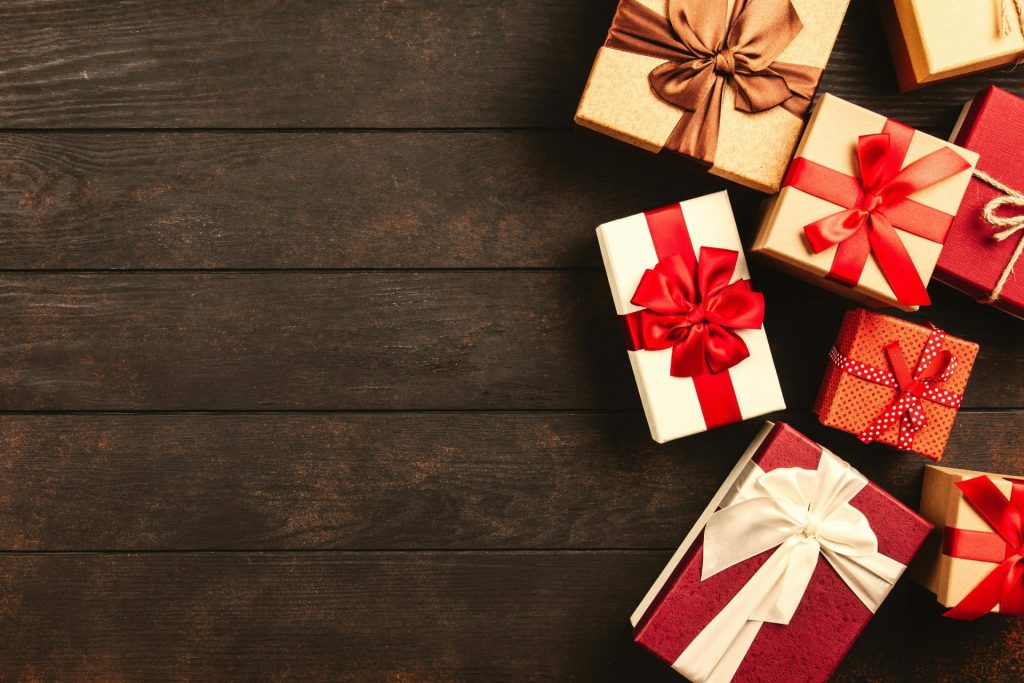 Beautifully wrapped holiday gifts with ribbons on a wooden surface, perfect for Christmas celebrations.